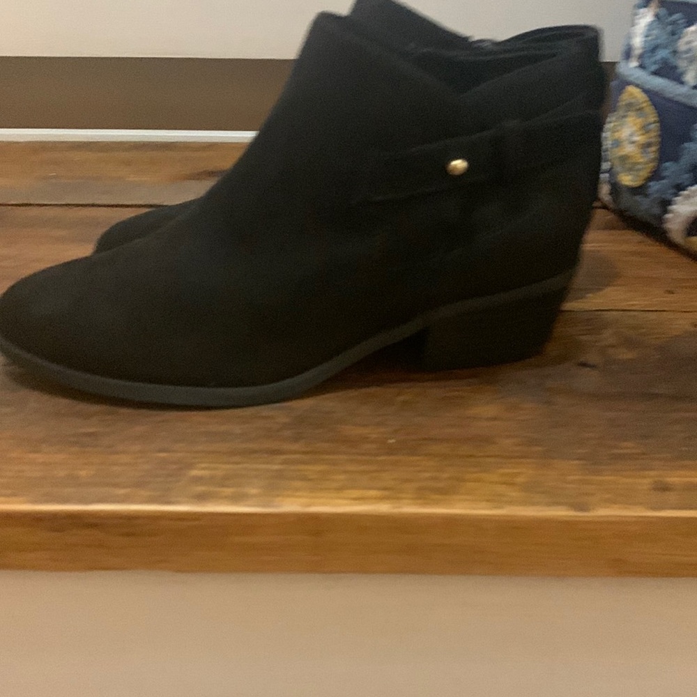 black ankle boots with zipper and buckle on the side with gold pin.
